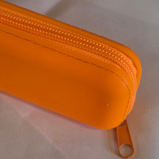 Close up of a bright orange cosmetic bag on a white background