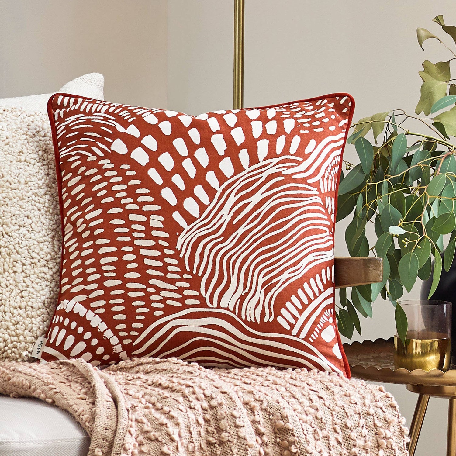 Nola minimalist geometric cushion with an abstract art print on neutral 100% cotton fabric, styled on a beige sofa and beige throw