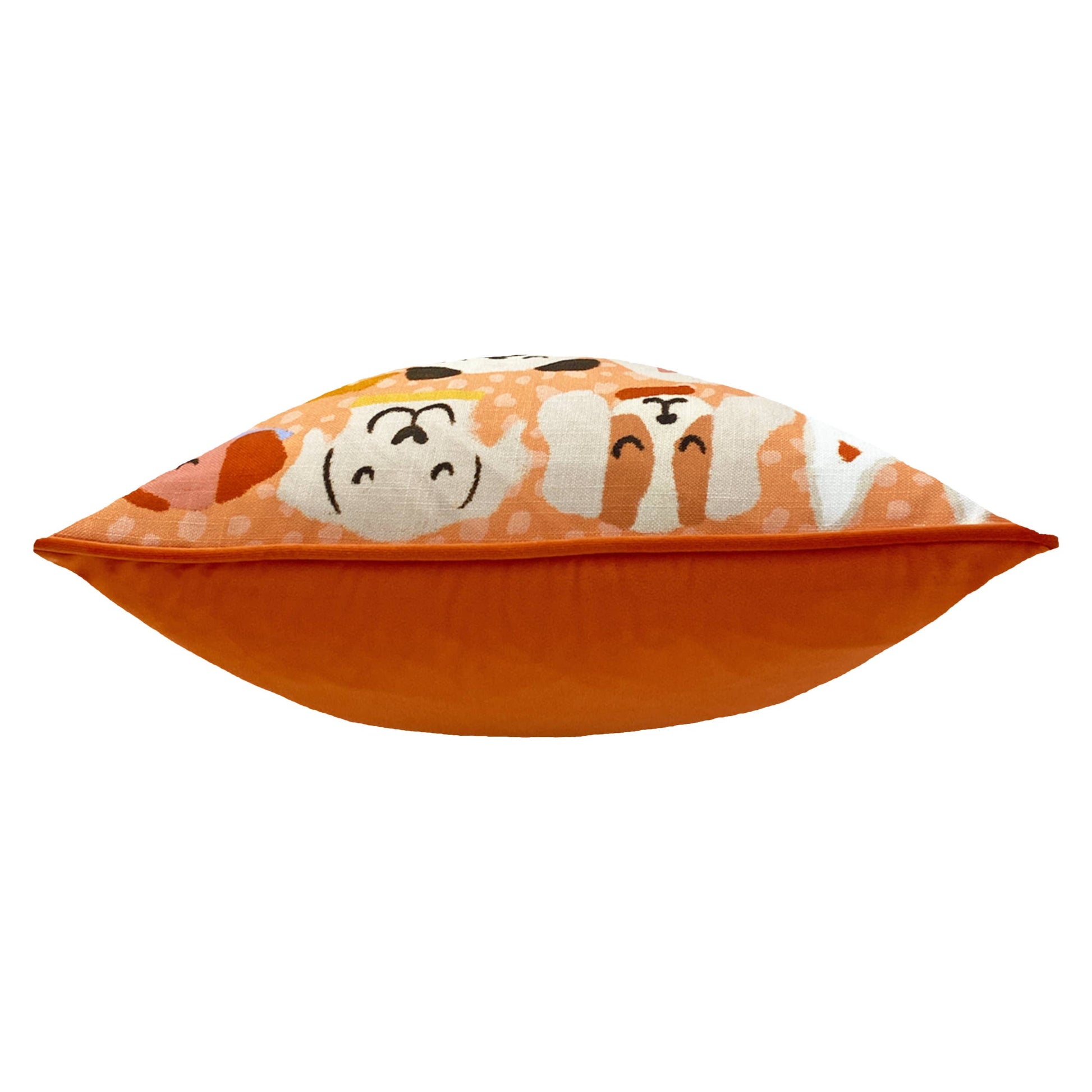 Orange pillow with cartoon dog faces on a white background