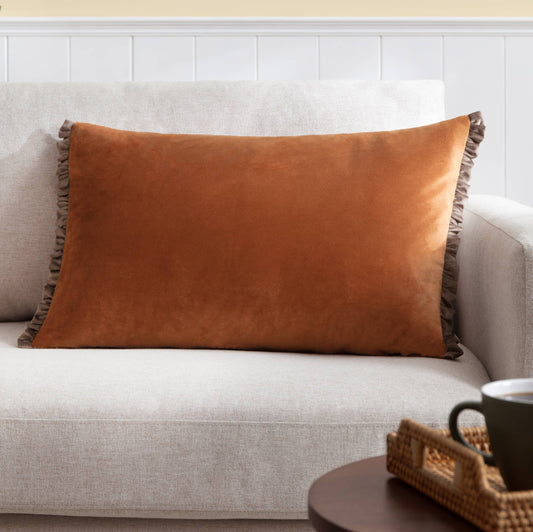 Tilly soft velvet lumbar cushion in rust burnt orange with a decorative ruffle frill edge, 40x60cm.
