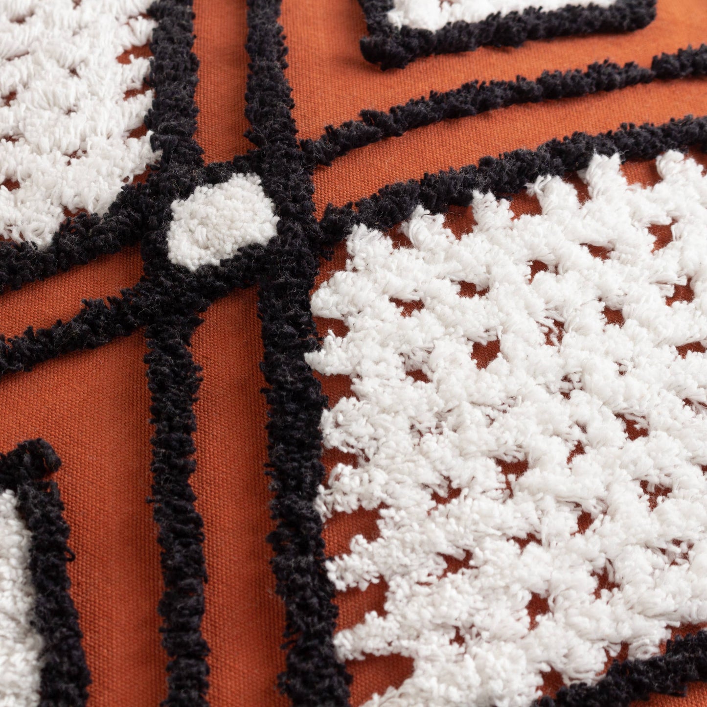 Close-up of the raised tufted texture and contrasting geometric lines on 100% cotton fabric.