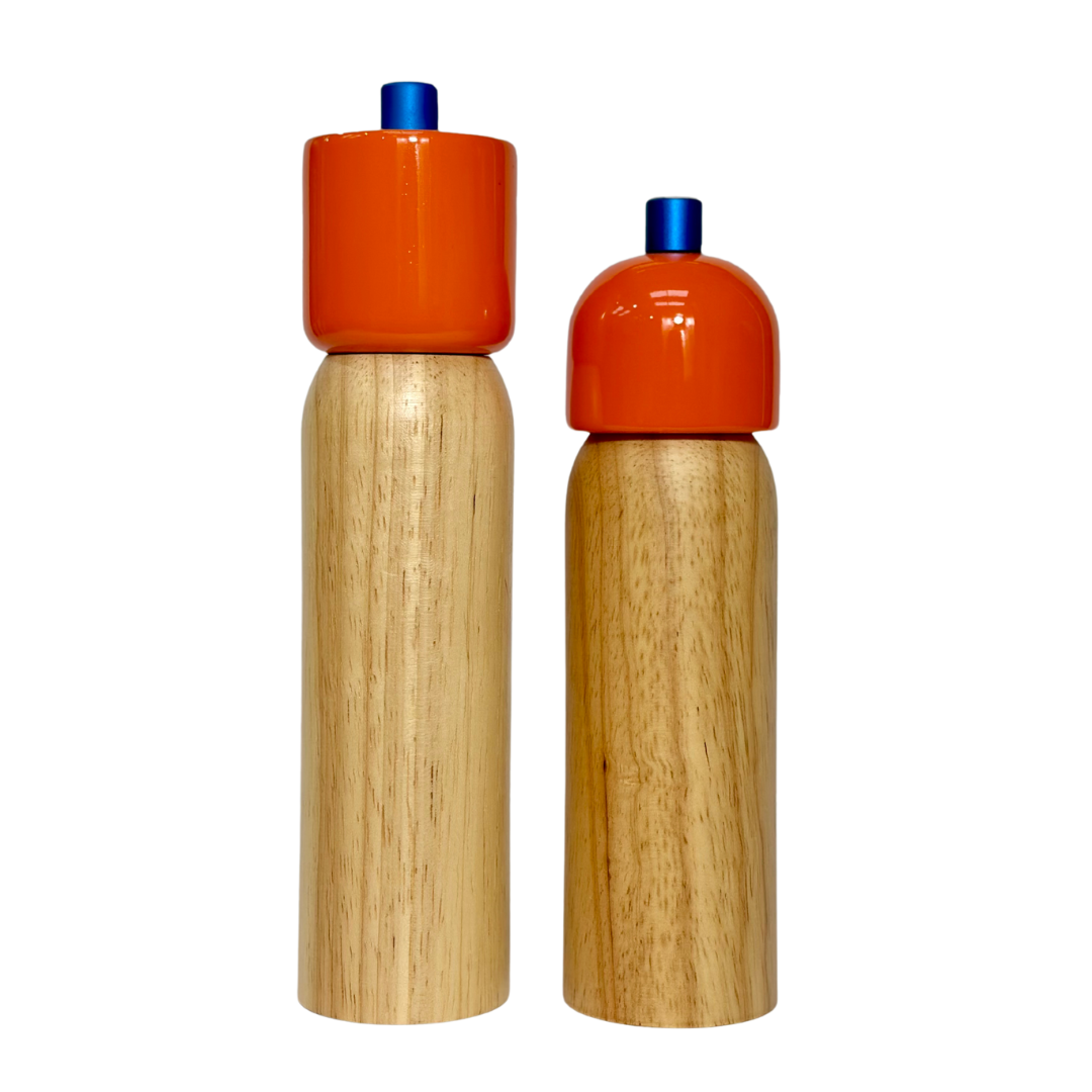 Two wooden salt and pepper shakers with orange tops on a white background