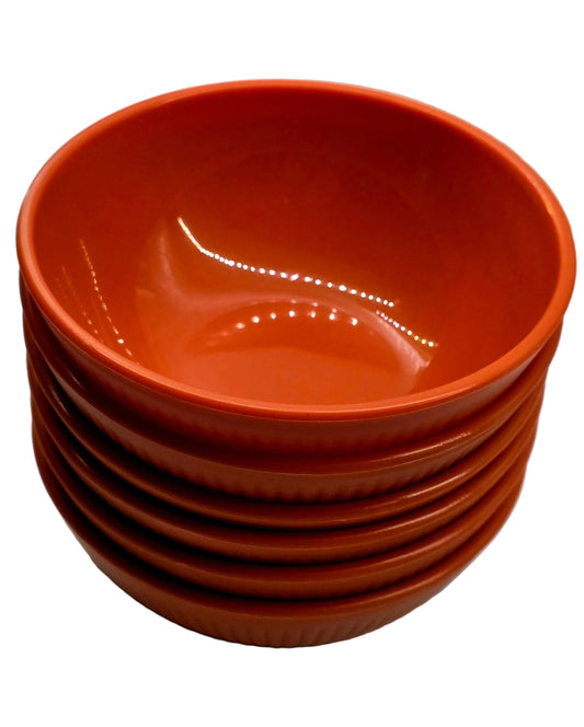 Stack of orange bowls on a white surface